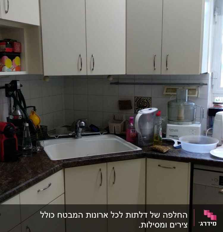 מטבח עם ארונות לבנים, כיור ומכשירי חשמל